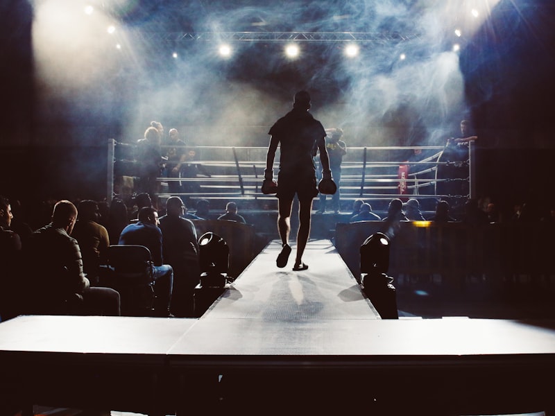 Kickbokser loopt naar de ring in een sfeervolle sporthal